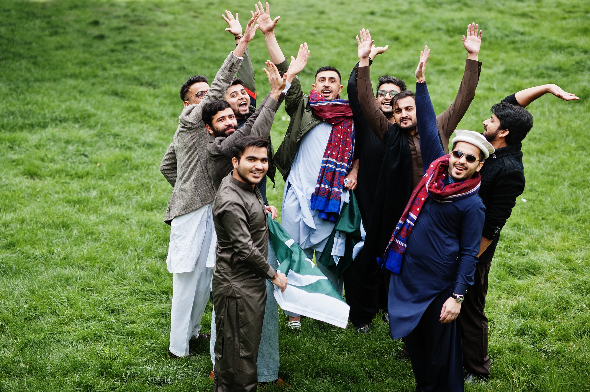 Group of pakistani man wearing traditional clothes salwar kameez or kurta with Pakistan flags.